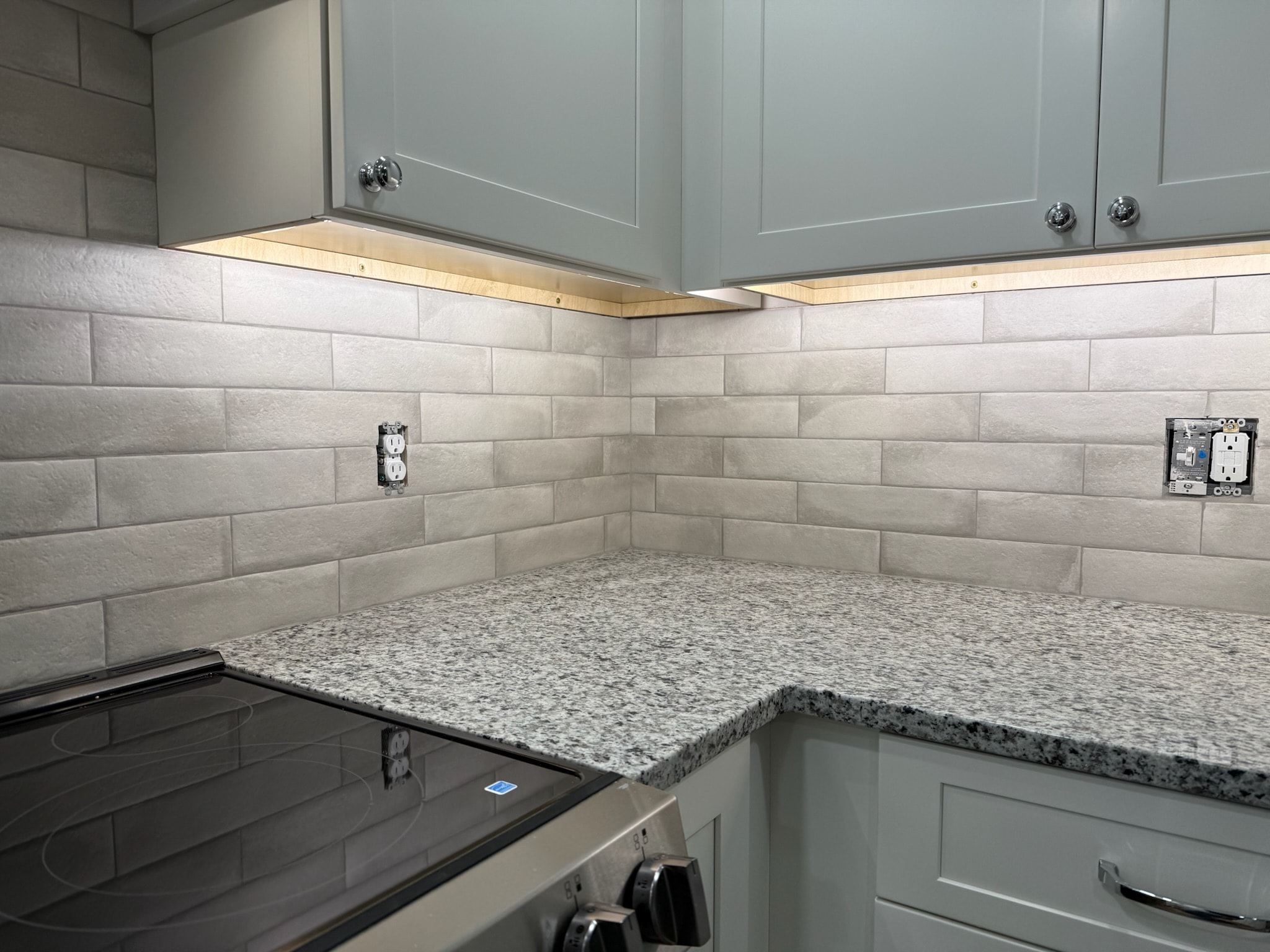 Cream subway tile with sage cabinets and granite